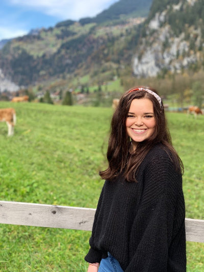 |Breanne who shares her testimony of Jesus Christ stands in a pasture of cows